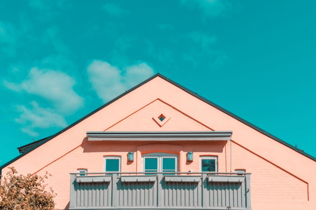 A pink and grey house against a blue sky